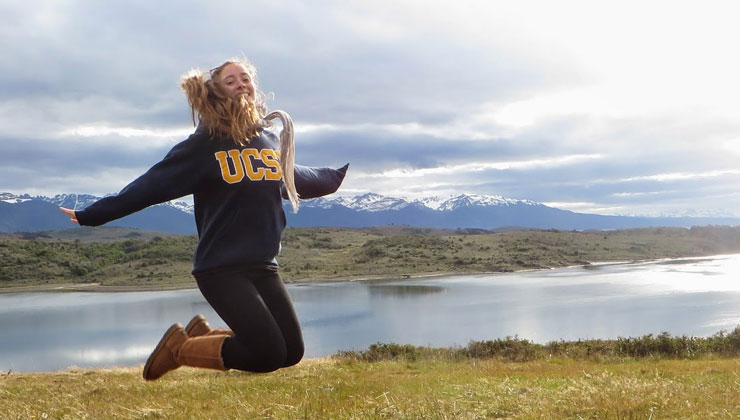 Student jumping in the air with a UC Santa Barbara sweatshirt in the outdoors of Patagonia, Argentina.