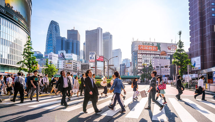 Tourists cross the busy crosswalk in the Shinjuku shopping district in Tokyo, Japan.
