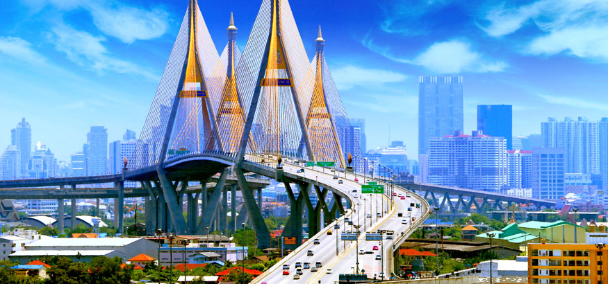 Bhumibol Bridge with traffic and blue buildings in the background in Bangkok, Thailand.