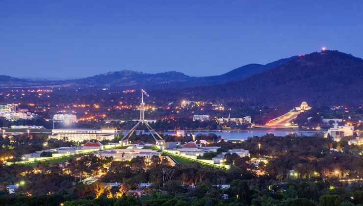 Canberra, Australia, lit up at dusk with city lights from Red Hill Lookout. 