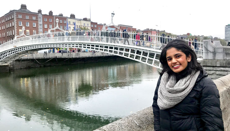 A student posing in front of Ha'penny bridge in Dublin Ireland.