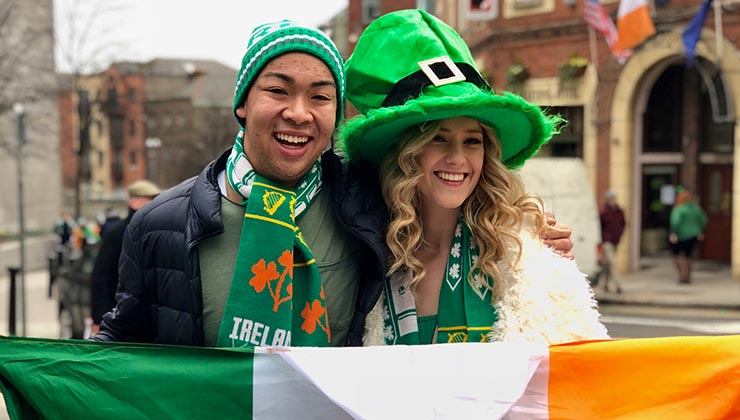 Students wearing hats and holding the Irish flag celebrate Saint Patrick's Day in Dublin, Ireland.