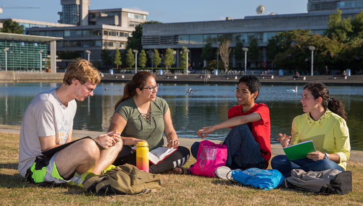 Four students sitting and talking on the University College Dublin campus in Dublin, Ireland.