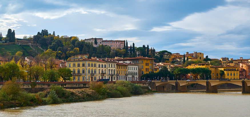 Colorful stucco villas, palazzo, stores and hotels overlooking the Arno River in Florence, Italy.