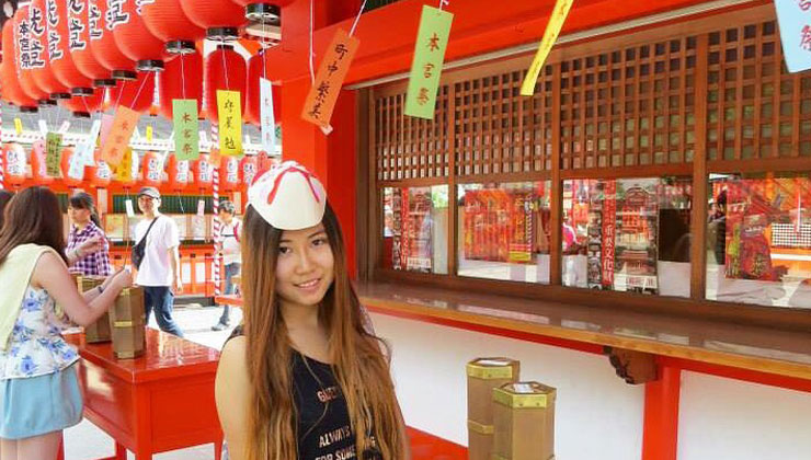 UC Santa Barbara student smiles at the Fushimi Inari Shrine in Kyoto, Japan.