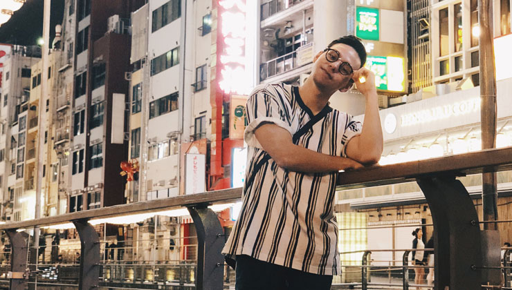 Student standing against a railing in Osaka, Japan.