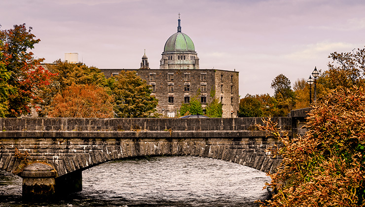 A view from across the water of the bridge over River Corrib and Galway Cathedral.