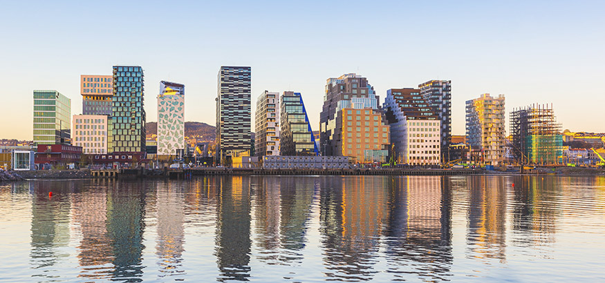 View of modern Oslo buildings, reflecting off the water at sunrise.