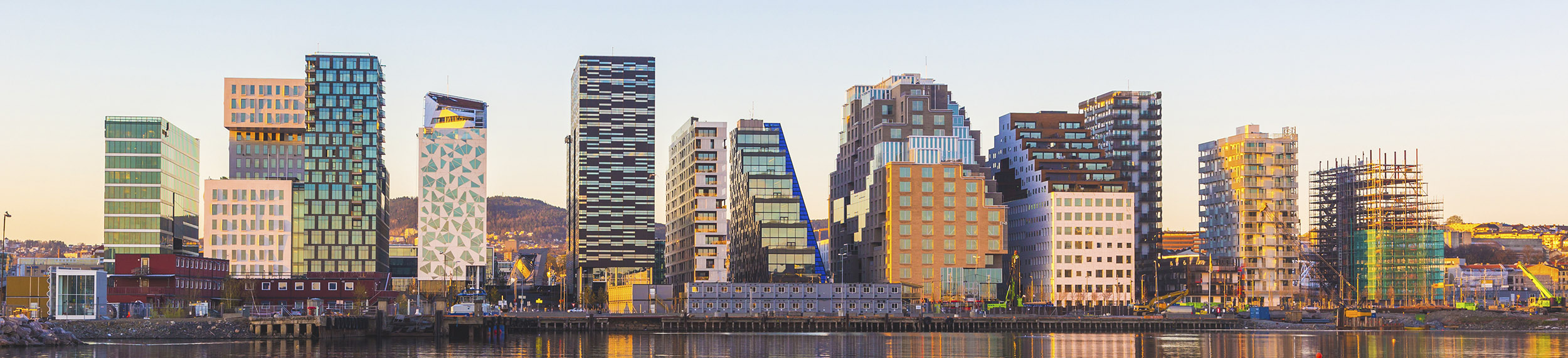 View of modern Oslo buildings, reflecting off the water at sunrise.