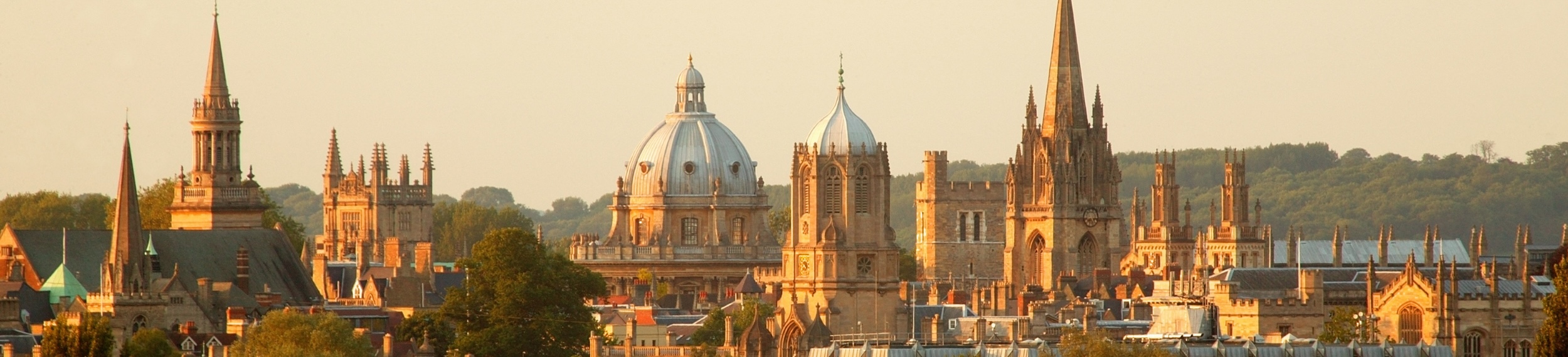 Castles and traditional buildings in the Oxford, UK skyline at sunset.