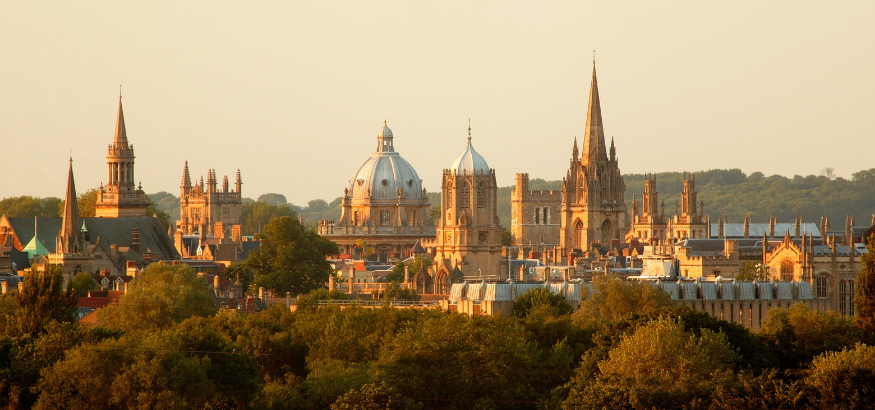 Castles and traditional buildings in the Oxford, UK skyline at sunset.