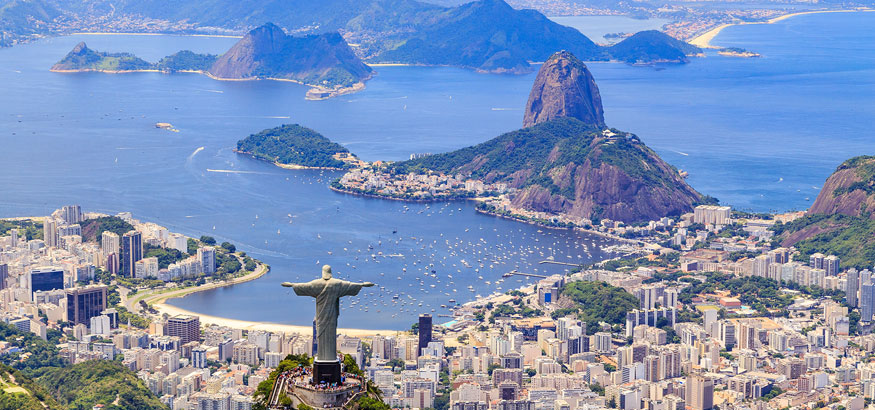 Aerial view of Christ The Redeemer Monument on Corcovado Mountain overlooking the water on a sunny day in Rio de Janeiro, Brazil.