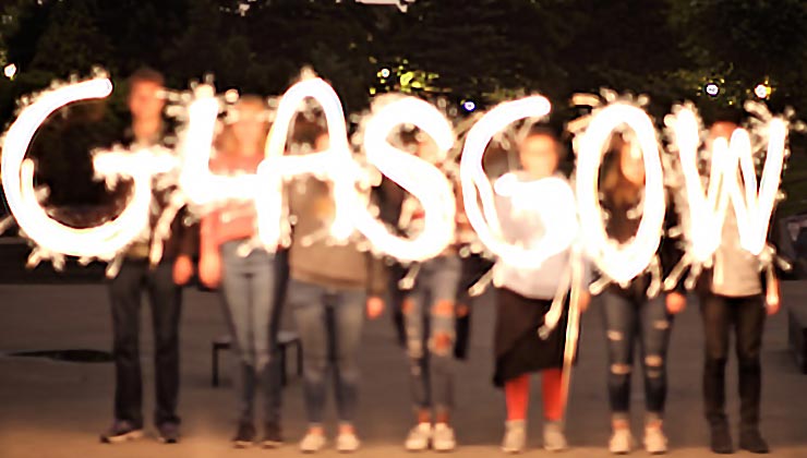 Students spell out Glasgow with sparklers at night at the University of Glasgow, Scotland.