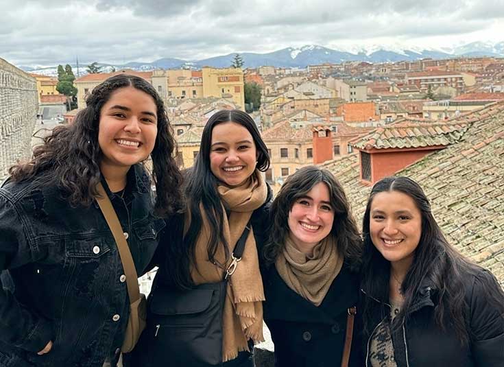 Group of students overlooking rooftops in Italy.