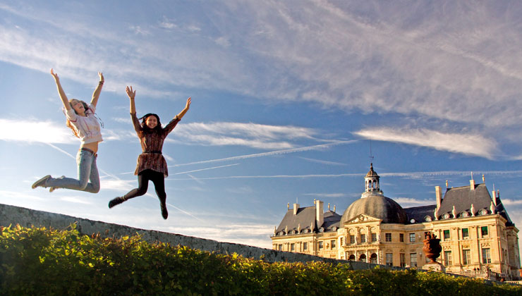 Students jumping at the Palace of Versailles in Versailles, France.