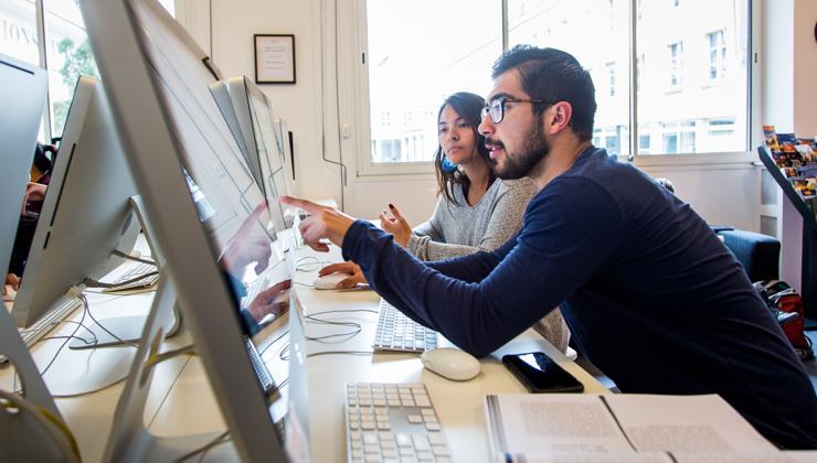 Two students pointing to a computer screen at Accent Paris in Paris France. 