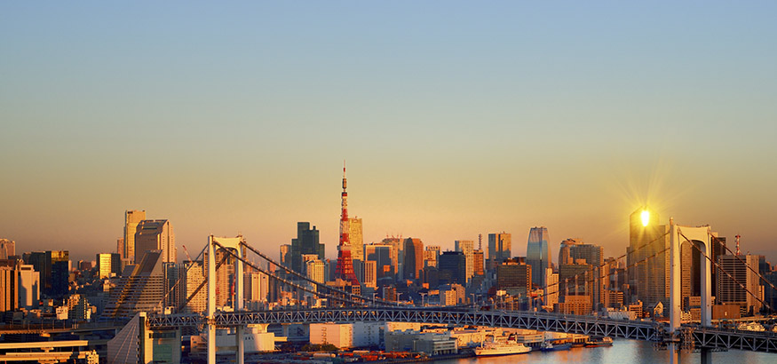 A view of the Tokyo cityscape over Tokyo Bay at sunrise. 