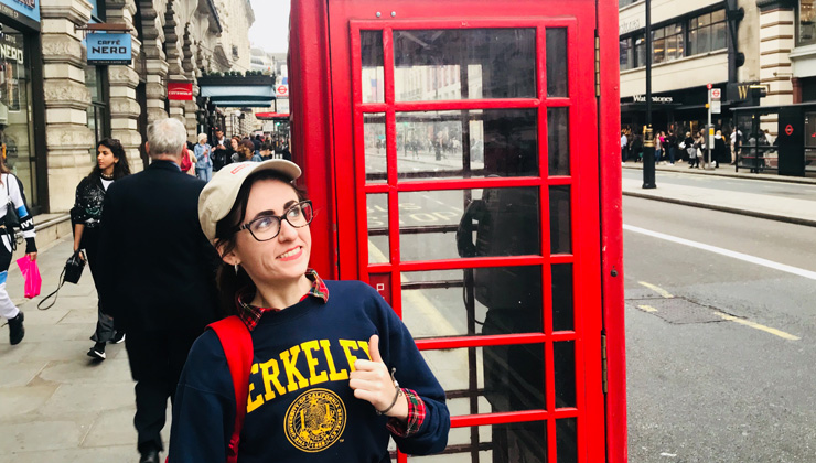 Student posing near a red telephone booth in London, England.