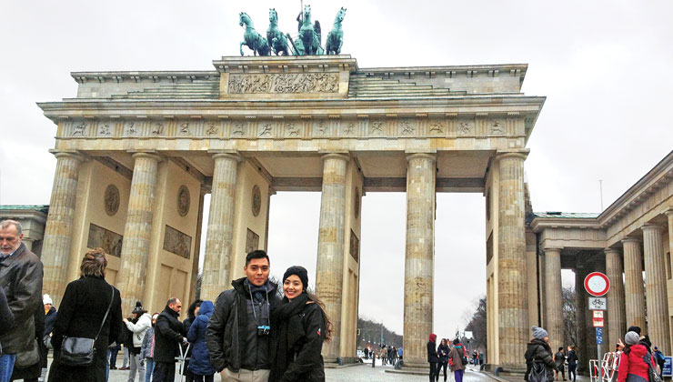 Two students smiling for the camera in front of the Brandenburg Gate in Berlin, Germany.
