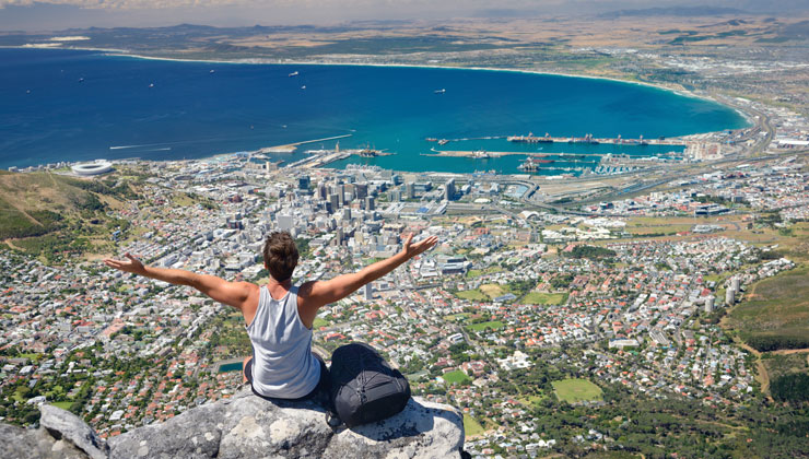 Student sitting on a rock after a hike and looking at the view in Cape Town South Africa. 