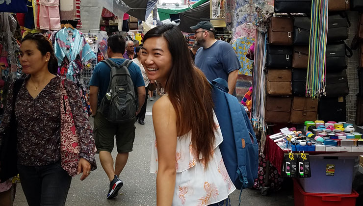 Student walks down a busy street in Hong Kong.