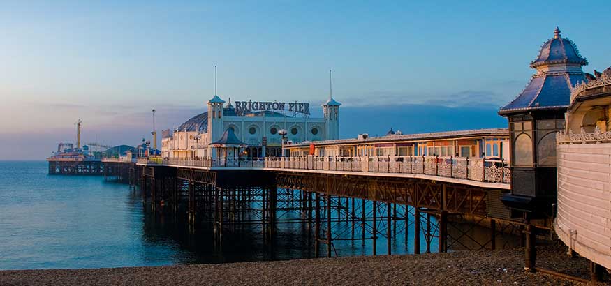 Pier in late afternoon light under blue skies, Brighton, East Sussex