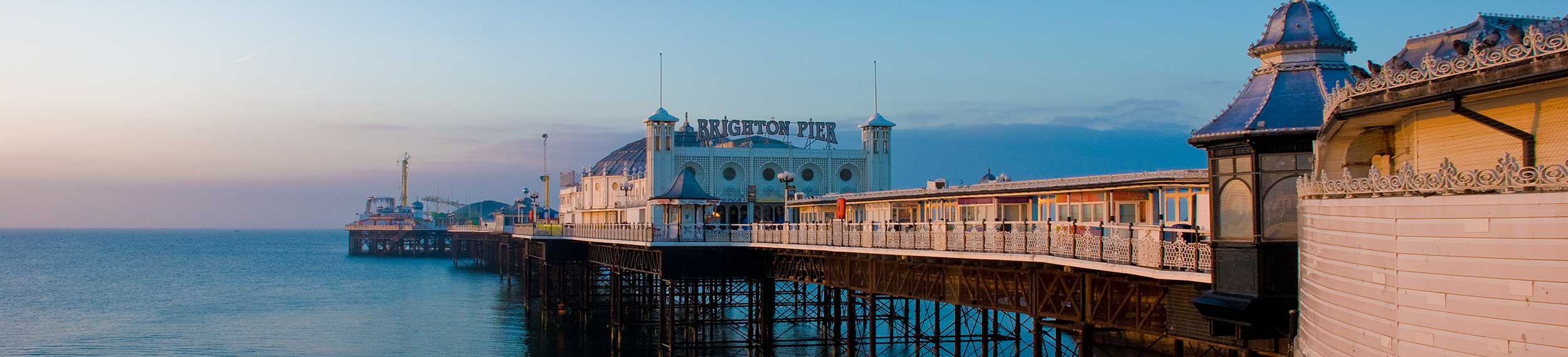 Pier in late afternoon light under blue skies, Brighton, East Sussex