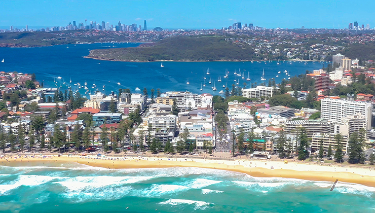 Aerial view of Manly Beach and in the distance city skyline of Sydney, Australia