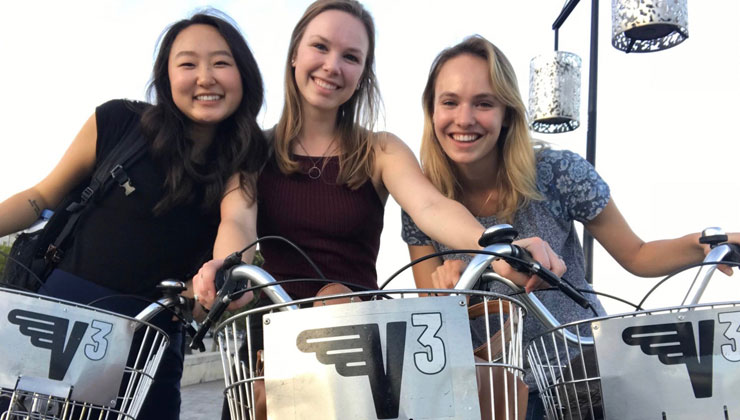 Three students on bikes posing in front of the camera in Bordeaux, France. 