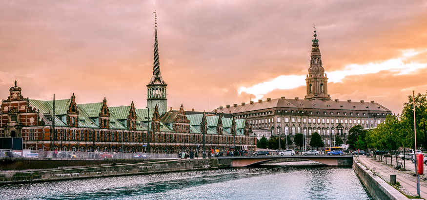 Sunset view of the Port of Copenhagen near the Stock Exchange Building and Christiansborg Castle in Copenhagen, Denmark.