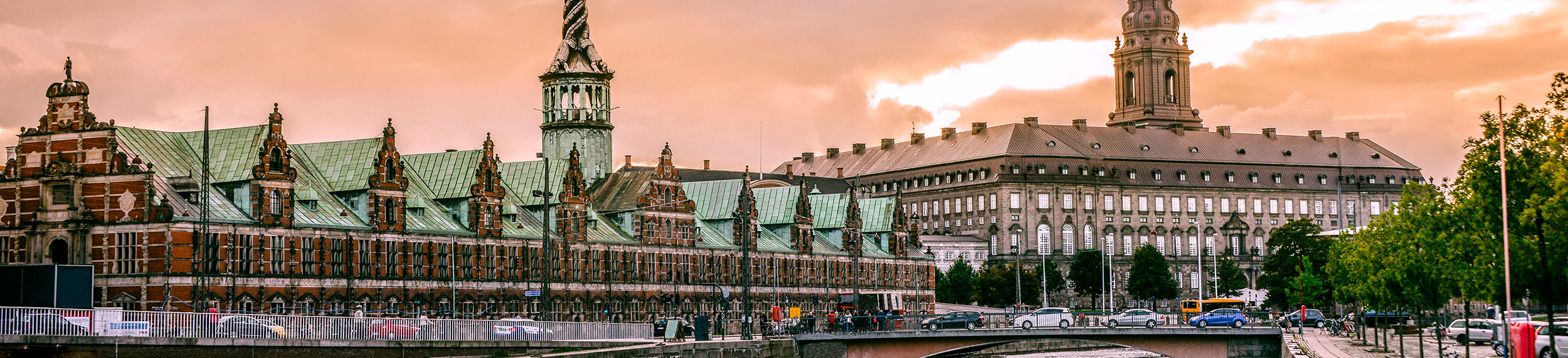 Sunset view of the Port of Copenhagen near the Stock Exchange Building and Christiansborg Castle in Copenhagen, Denmark.