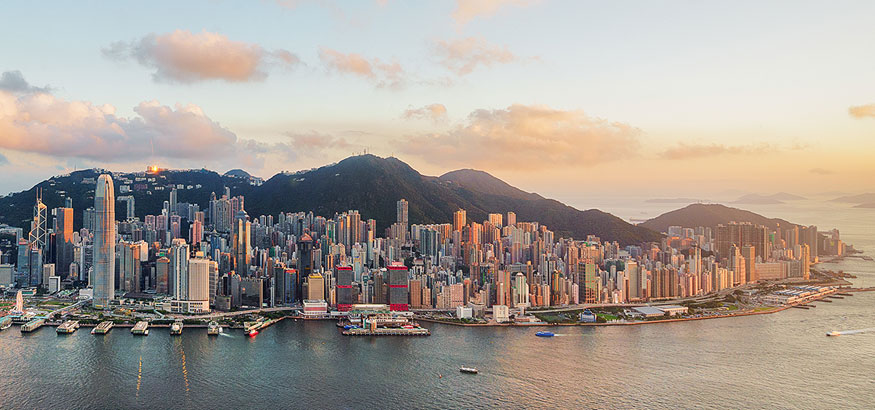 Aerial shot of Victoria Harbor and Hong Kong skyline at sunset