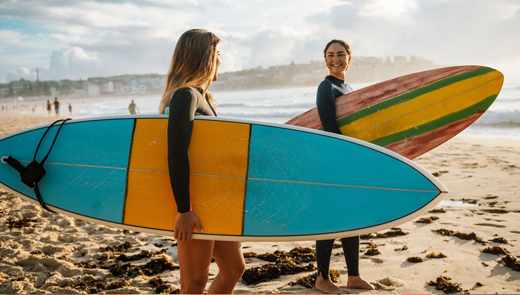 Two students holding surfboards in Melbourne, Australia.