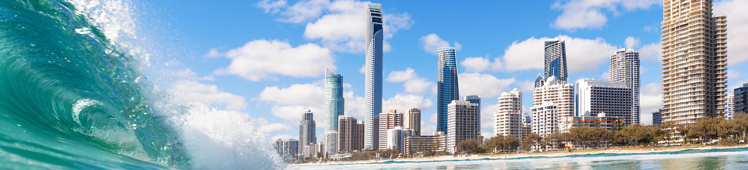 Aqua colored waves and skyline at Surfers Paradise Beach in Queensland, Australia.
