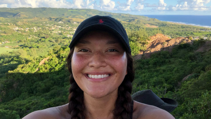 Student smiles for a selfie while hiking around lush vegetation on the east coast of Barbados.