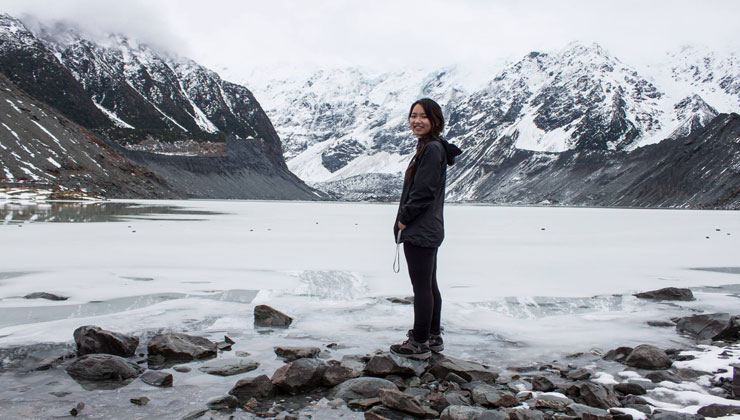 UCEAP student smiling with a view of mountains covered in snow and a frozen lake in New Zealand.