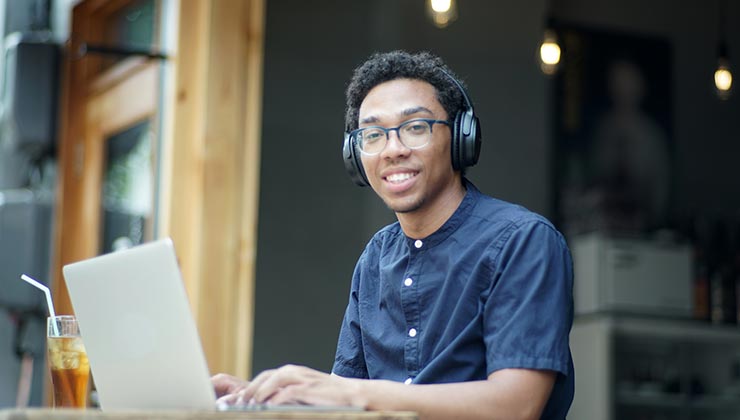 Student intern enjoying working on laptop at a café.