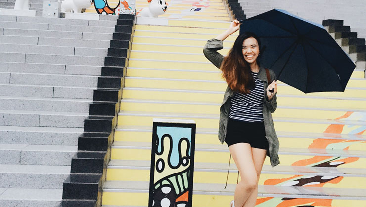UC San Diego student poses with a black umbrella on the colorful steps of the Yongsan Station in Seoul, South Korea. 