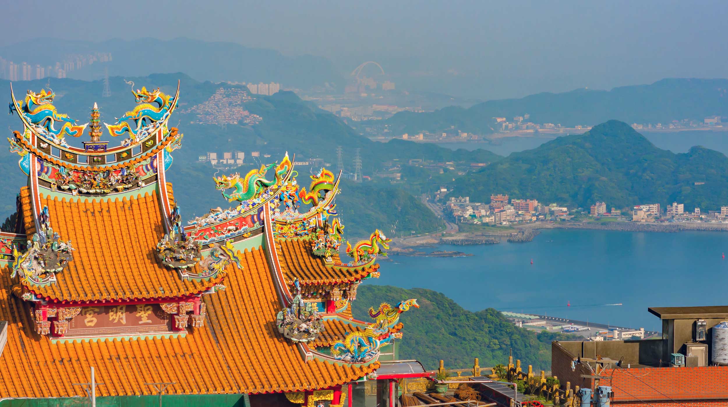 Coastal view of Taiwanese village of Jiufen, northeast of the island, with traditional building in foreground.