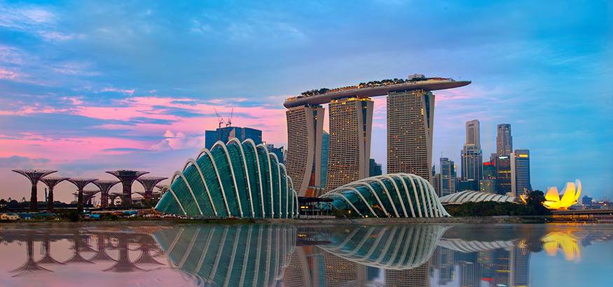 The Singapore skyline at night with the the Gardens by the Bay on the left, three towers of the Marina Bay Sands in the middle, and the ArtScience Museum on the right.