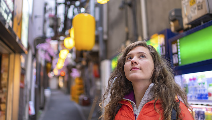 Back view of a student as they explore Shinjuku street in Nishishinjuku, Tokyo, Japan. 