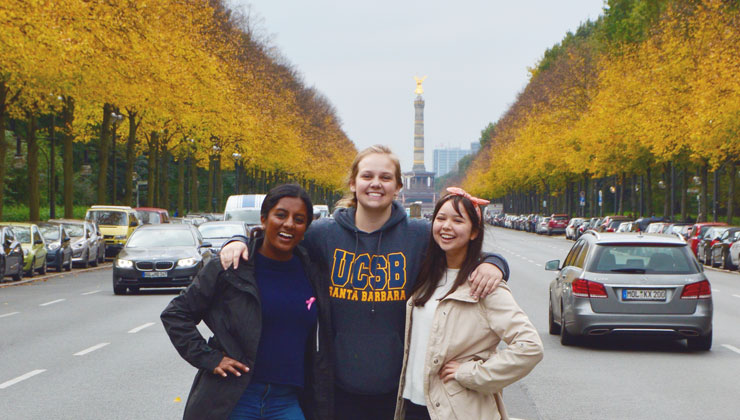 Kate Bell poses with arms around her friends on a tree-lined street of Berlin, Germany.