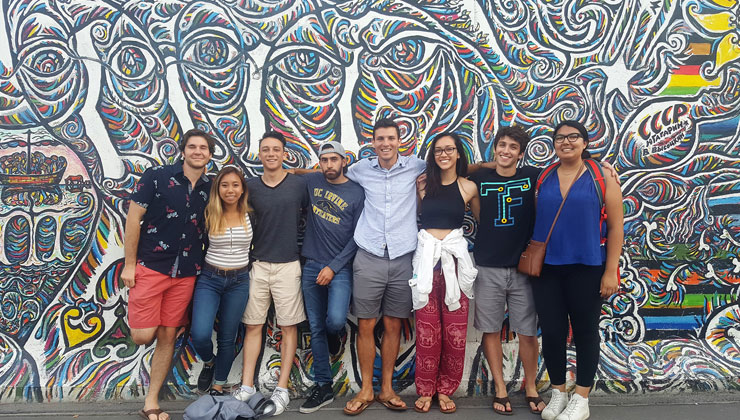 Sidney Crossley, aka “Trey,” poses with friends in front of the colorful section of the Berlin Wall in Berlin, Germany.