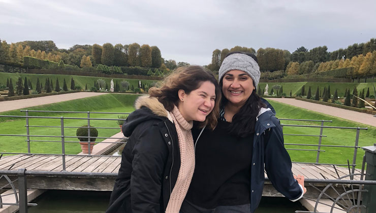 Two students smiling near a grassy open area in Copenhagen, Denmark.