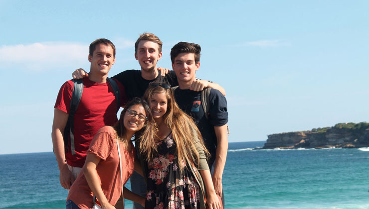 Five students pose for a picture near a beach in Sydney, Australia.
