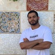 Christopher Kallah poses for a picture near a colorful wall in Spain. 