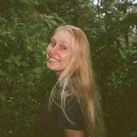 Eleanor Terner smiles for a photo in a foresty area. 