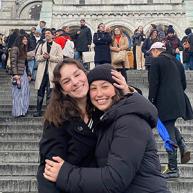 Catherine Parker and a friend pose in front a crowded set of steps.