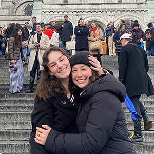 Catherine Parker and a friend pose in front a crowded set of steps.